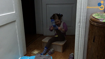 Девочка самостоятельно надевает носки и обувь